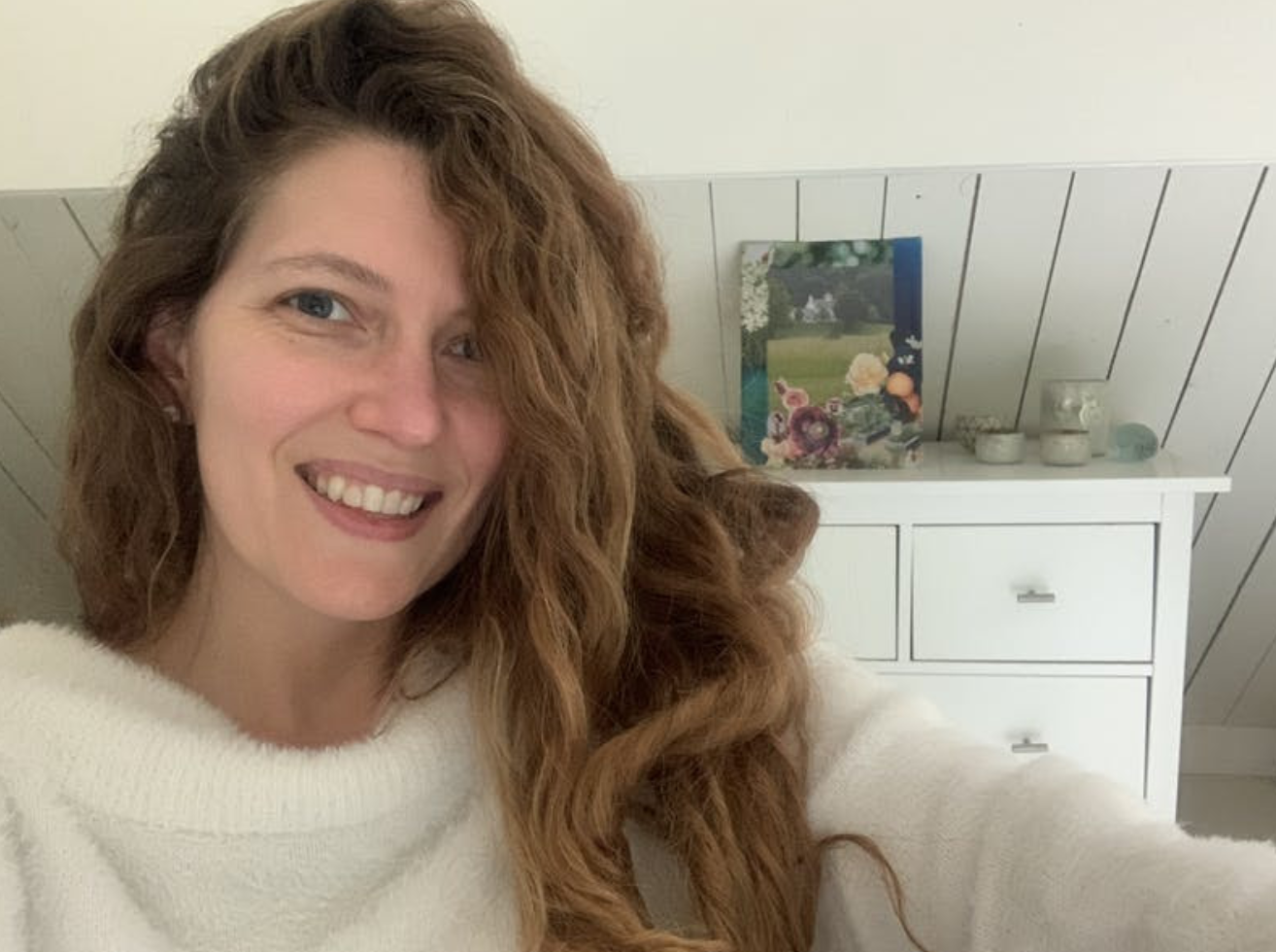 Katherine North smiling with her vision board behind her